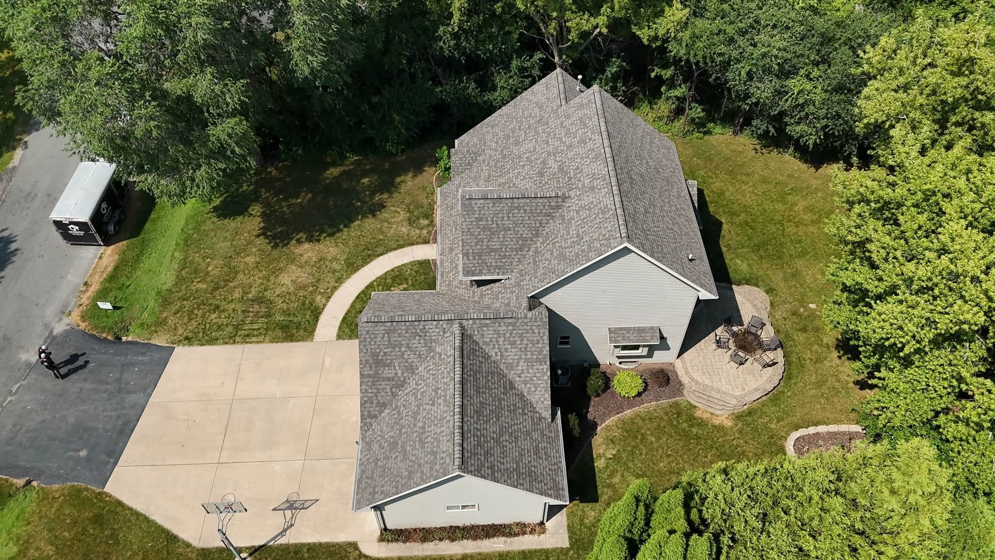 Wide aerial view of a completed gray shingle roof replacement