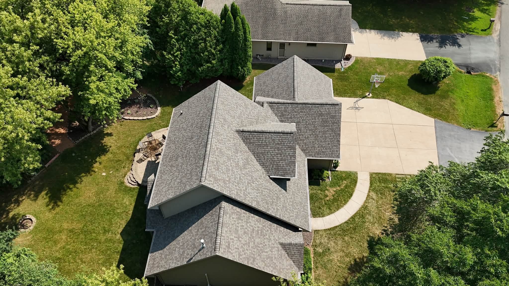 Rear drone view of a completed gray shingle roof replacement