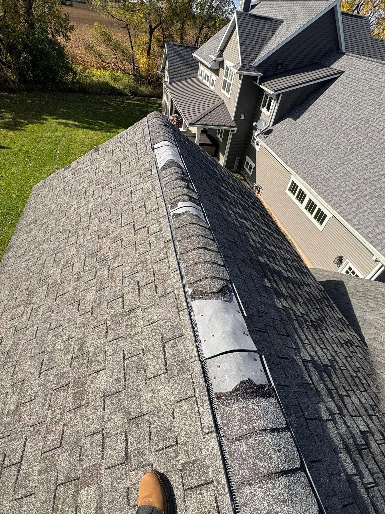 Residential roof ridge with several ridge-cap shingles missing